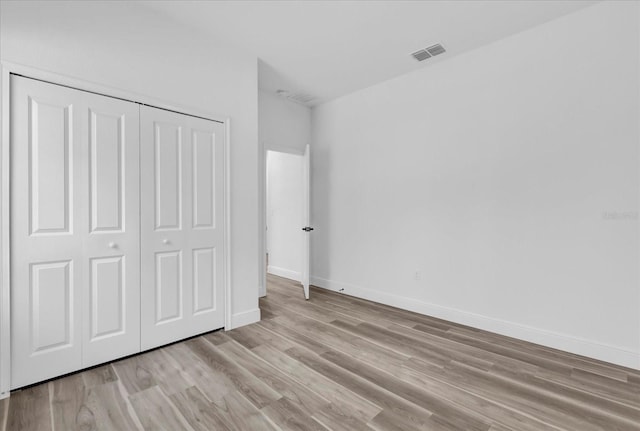 unfurnished bedroom featuring a closet and light hardwood / wood-style floors