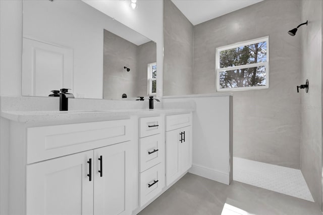 bathroom with vanity and tiled shower