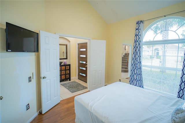 bedroom featuring high vaulted ceiling and hardwood / wood-style flooring