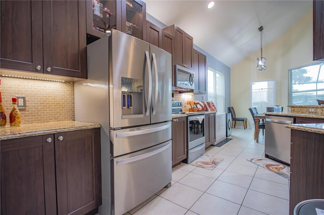 kitchen with tasteful backsplash, light stone counters, lofted ceiling, and appliances with stainless steel finishes