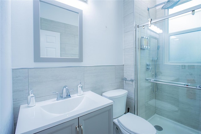 bathroom with vanity, an enclosed shower, tile walls, and toilet