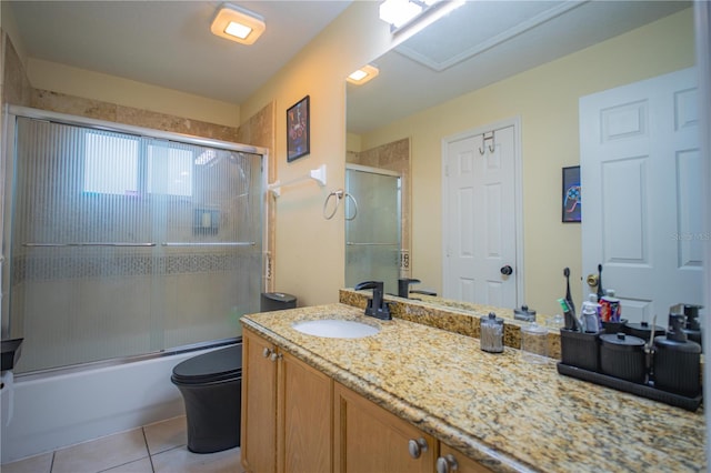 full bathroom with toilet, vanity, tile patterned floors, and bath / shower combo with glass door