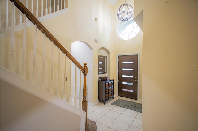 tiled foyer featuring a high ceiling and an inviting chandelier