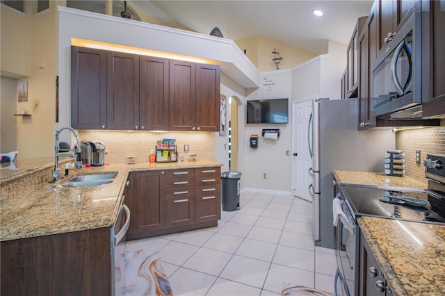 kitchen with sink, decorative backsplash, light tile patterned floors, appliances with stainless steel finishes, and light stone counters