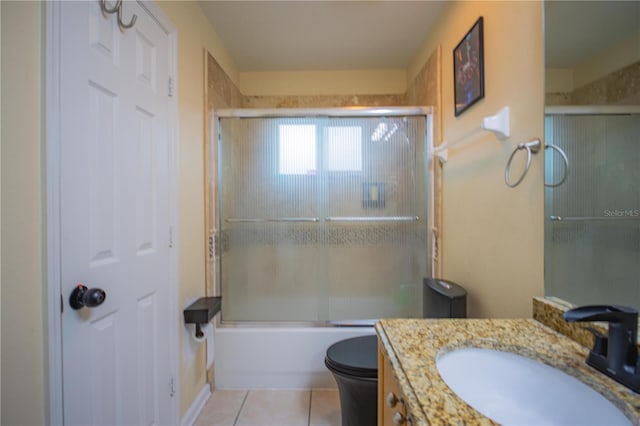 full bathroom with tile patterned floors, vanity, combined bath / shower with glass door, and toilet