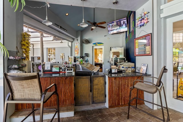 bar featuring vaulted ceiling, hanging light fixtures, a healthy amount of sunlight, and ceiling fan