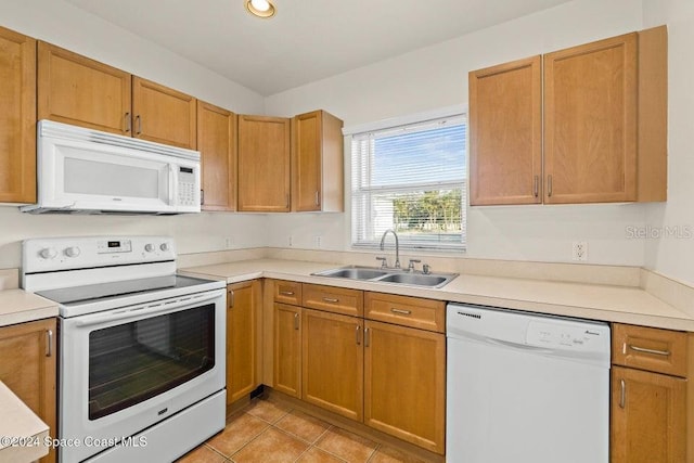 kitchen with light tile patterned flooring, white appliances, and sink