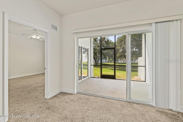 doorway with ceiling fan, light carpet, and a wealth of natural light