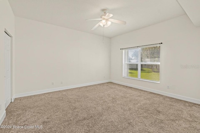 carpeted spare room with ceiling fan