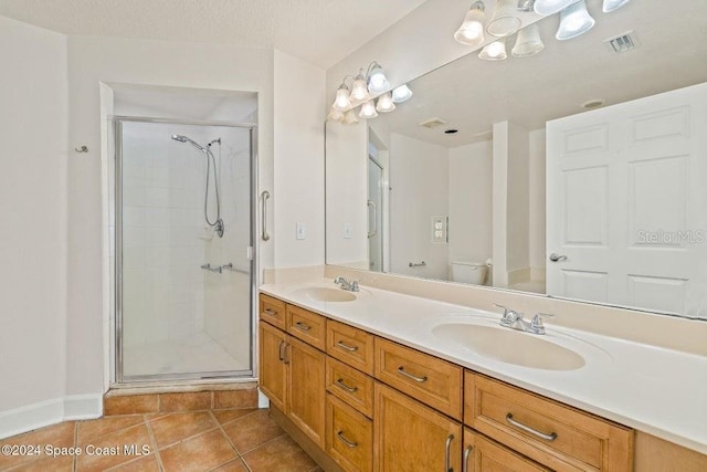 bathroom with vanity, a shower with door, tile patterned flooring, and toilet