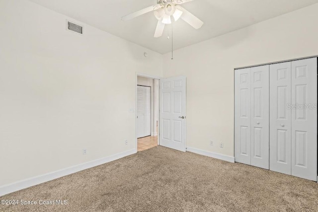 unfurnished bedroom featuring a closet, light colored carpet, and ceiling fan