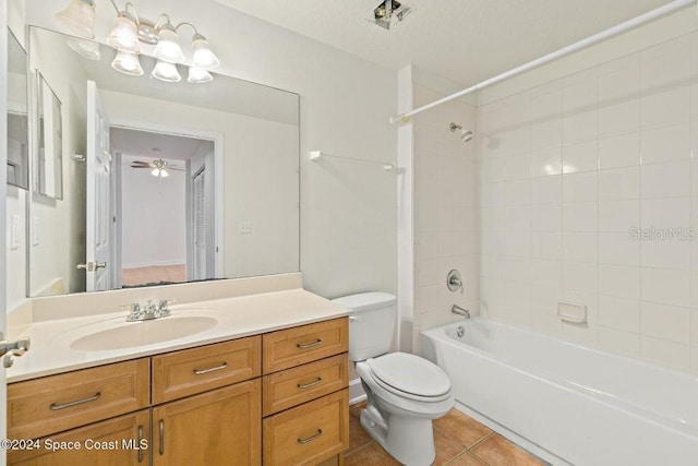 full bathroom with ceiling fan, tile patterned floors, toilet, vanity, and tiled shower / bath