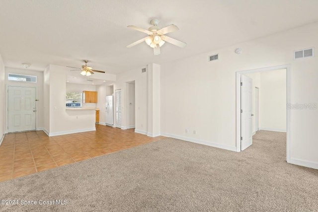 unfurnished living room featuring ceiling fan and light carpet