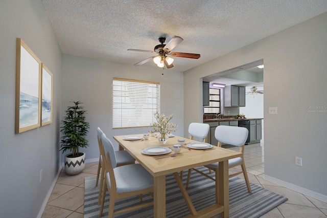 tiled dining room with ceiling fan, sink, and a textured ceiling