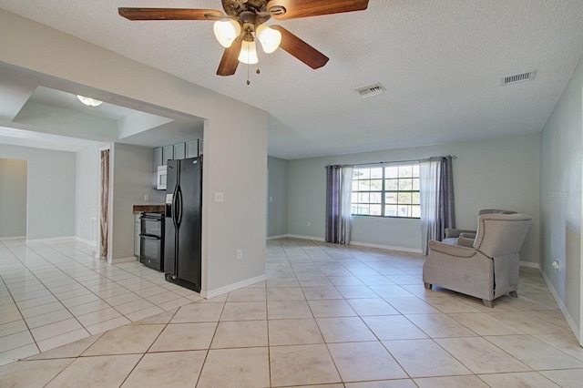 unfurnished room featuring light tile patterned floors, a textured ceiling, and ceiling fan