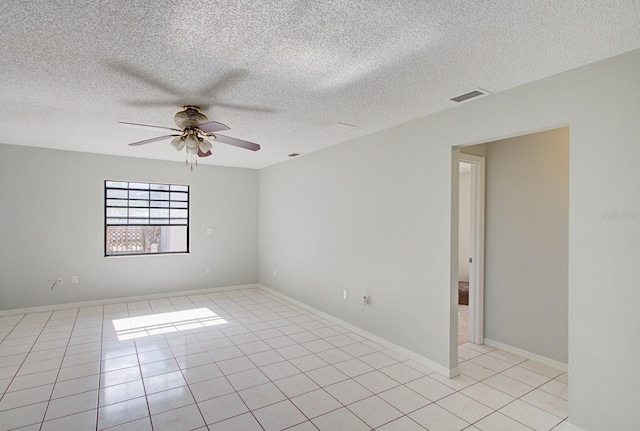 spare room with light tile patterned floors, a textured ceiling, and ceiling fan