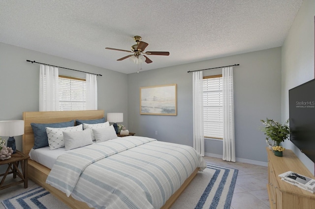 bedroom with multiple windows, ceiling fan, and a textured ceiling