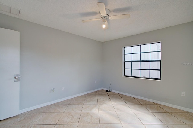 tiled spare room featuring ceiling fan and a textured ceiling