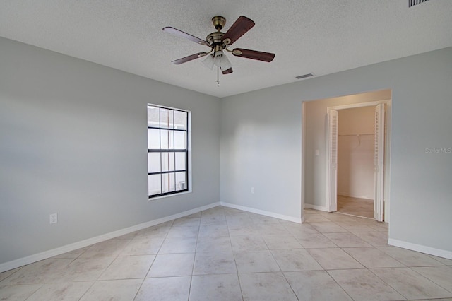 tiled spare room featuring ceiling fan and a textured ceiling