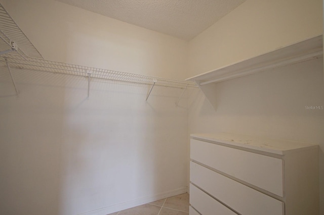 spacious closet with light tile patterned floors