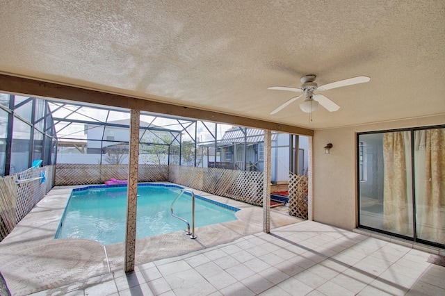 view of swimming pool featuring glass enclosure, ceiling fan, and a patio