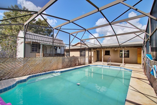 view of pool with glass enclosure, ceiling fan, and a patio