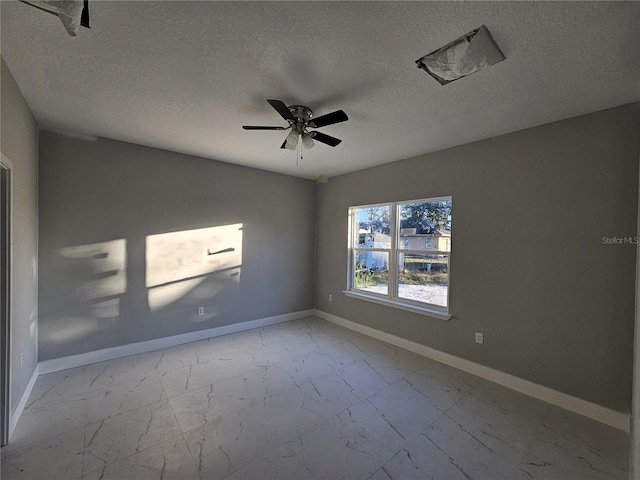 spare room with a textured ceiling and ceiling fan