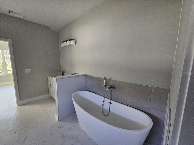 bathroom featuring a washtub and vanity