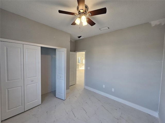 unfurnished bedroom with ceiling fan and a closet