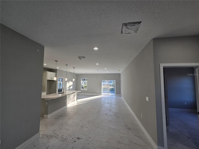 unfurnished living room with a textured ceiling and sink