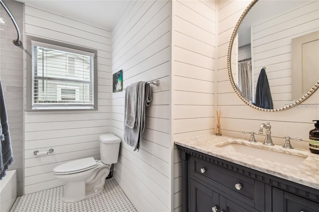 bathroom with toilet, wooden walls, shower / tub combo, vanity, and tile patterned floors