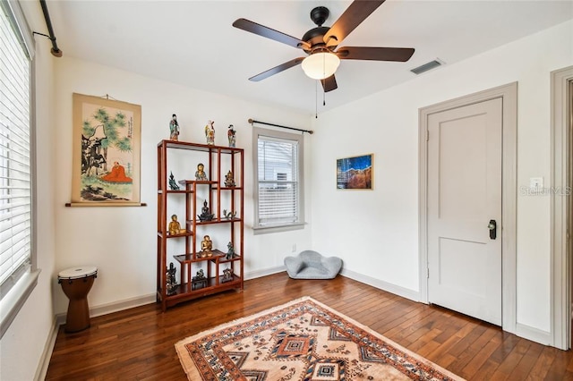 sitting room featuring baseboards, visible vents, and dark wood finished floors