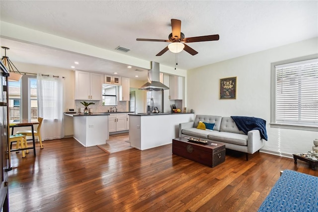 living room with dark wood-style floors, recessed lighting, visible vents, and ceiling fan