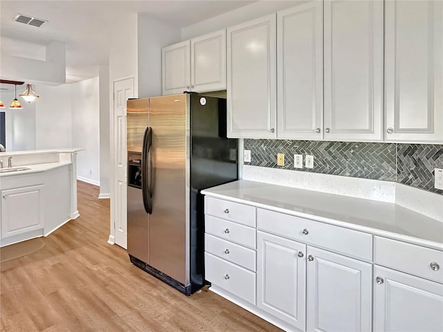 kitchen featuring white cabinets, sink, light wood-type flooring, tasteful backsplash, and stainless steel fridge with ice dispenser