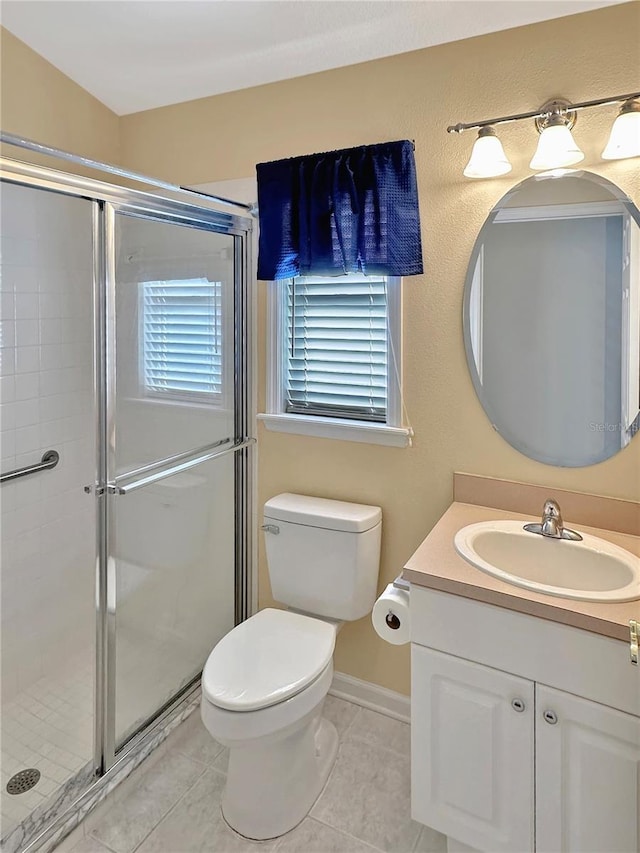 bathroom with toilet, vanity, tile patterned floors, and a shower with door