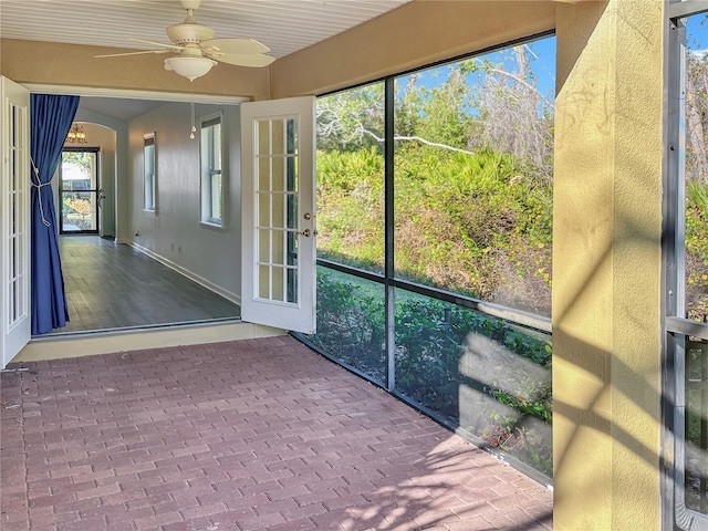 unfurnished sunroom featuring ceiling fan