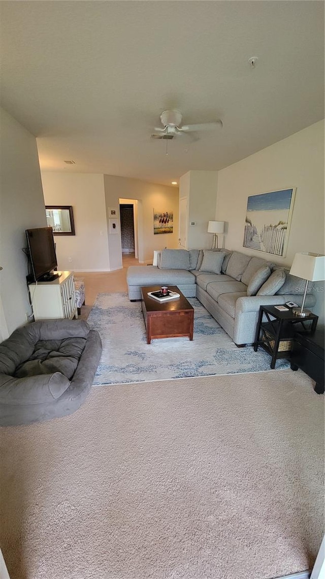 carpeted living room with ceiling fan