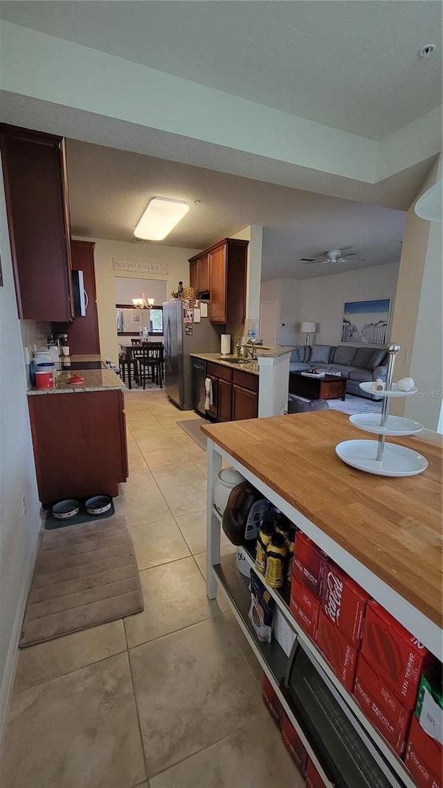 kitchen featuring stainless steel fridge, light tile patterned floors, and sink