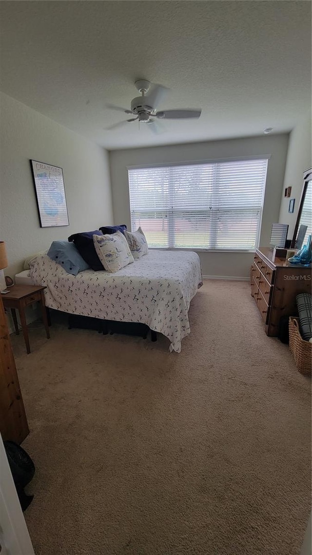 carpeted bedroom featuring multiple windows and ceiling fan