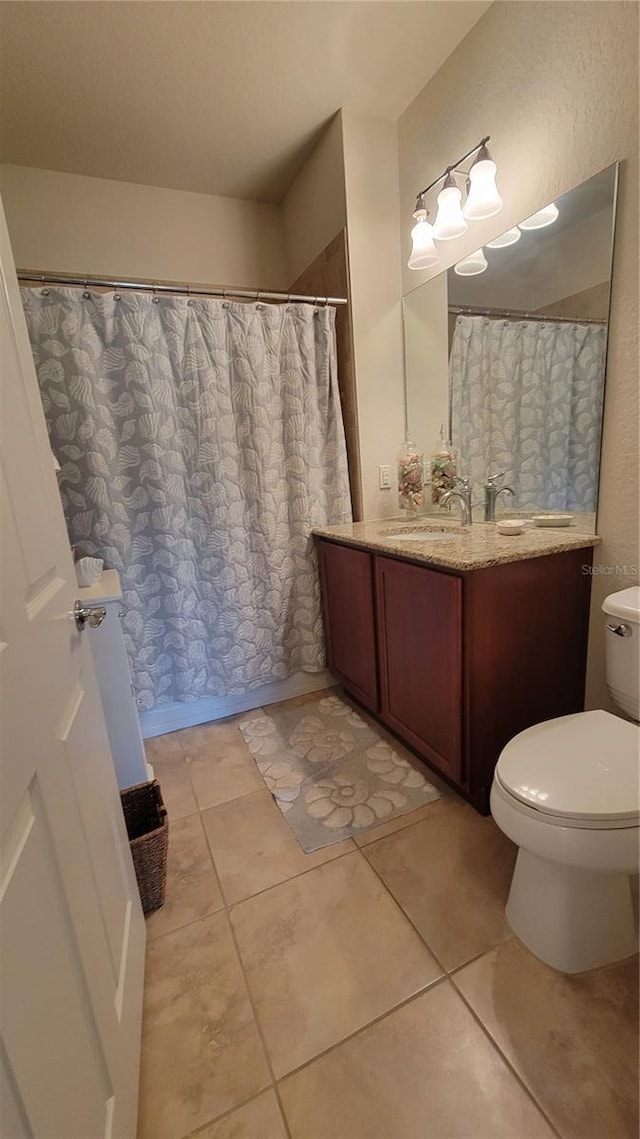 bathroom featuring tile patterned flooring, vanity, and toilet