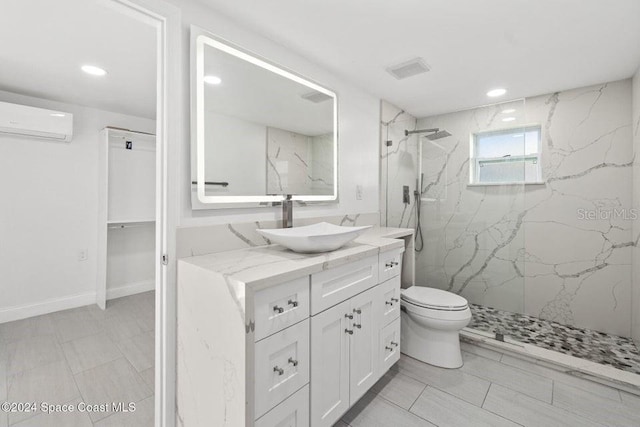 bathroom with vanity, toilet, tiled shower, and a wall unit AC