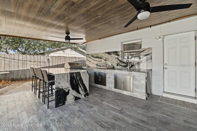 view of patio with ceiling fan, area for grilling, exterior kitchen, and an outdoor wet bar