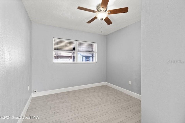 unfurnished room with a textured ceiling, light wood-type flooring, and ceiling fan