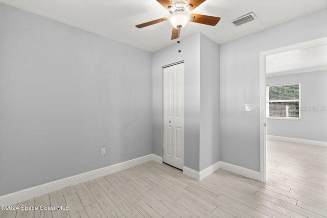 unfurnished bedroom featuring a closet, light hardwood / wood-style flooring, and ceiling fan