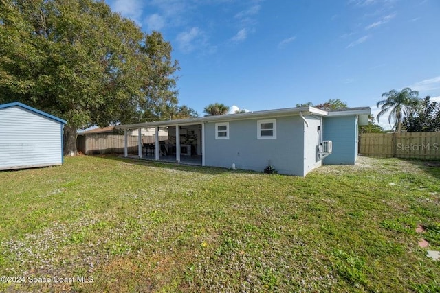 back of property featuring a lawn and a storage shed