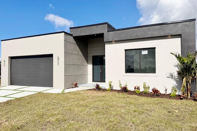 contemporary house featuring a front lawn and a garage