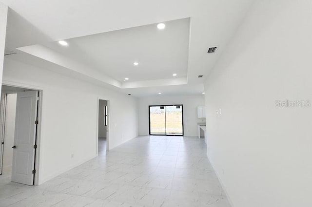 unfurnished room featuring a raised ceiling