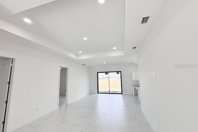 spare room with a tray ceiling