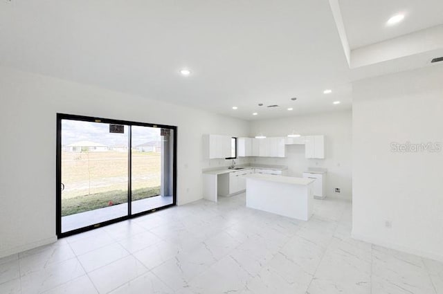 kitchen with a center island, white cabinets, and sink