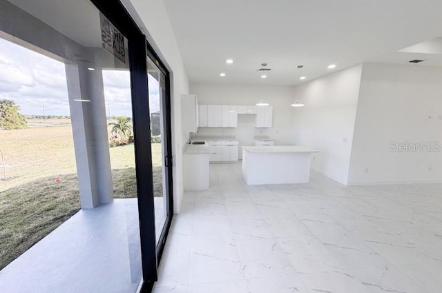 kitchen featuring white cabinets, a kitchen island, and sink